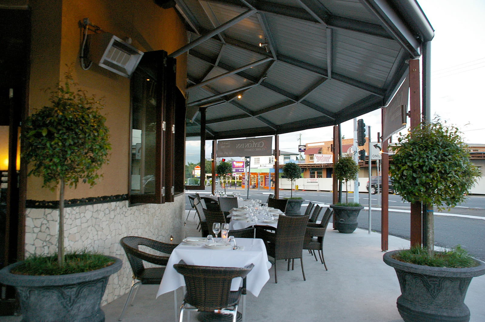 Outdoor street-side dining patio with set tables