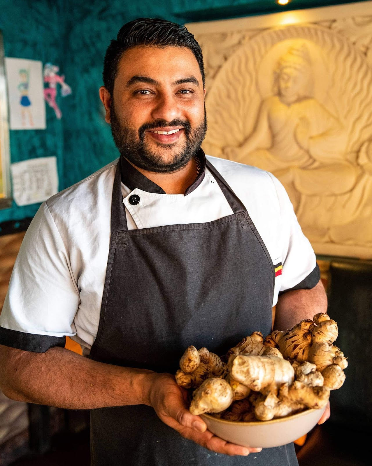 Chef holding a bowl of fresh ginger for Indian cooking